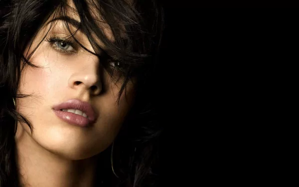HD desktop wallpaper featuring a stunning portrait of Megan Fox against a black background.