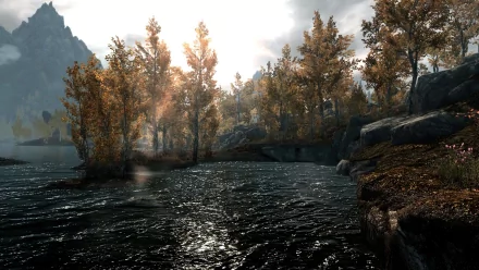 A serene landscape from The Elder Scrolls V: Skyrim featuring a tranquil river surrounded by autumn trees and distant mountains, captured in high-definition for a stunning desktop wallpaper.