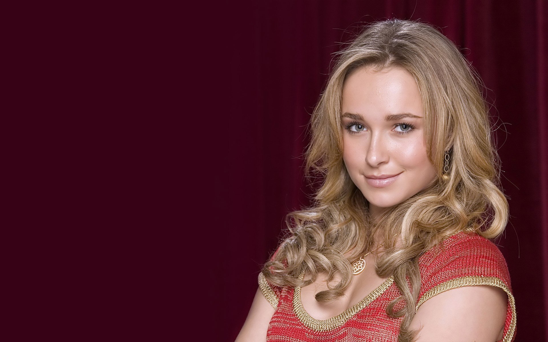 HD PC desktop wallpaper featuring celebrity Hayden Panettiere with wavy blonde hair and a red top against a dark red background.