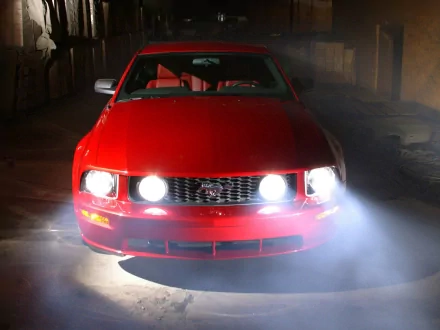 Red 2005 Ford Mustang vehicle, front view with headlights cutting through fog — HD PC desktop wallpaper/background.