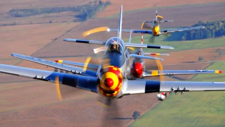 A stunning HD wallpaper features military aircraft soaring through the skies, showcasing their vibrant colors and sleek designs against a picturesque landscape.