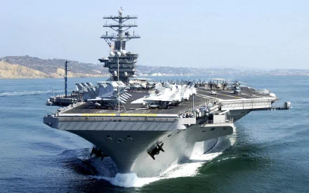 A stunning HD image of the USS Nimitz (CVN-68), a prominent aircraft carrier, sailing through calm waters, showcasing its impressive military presence and sophisticated design.