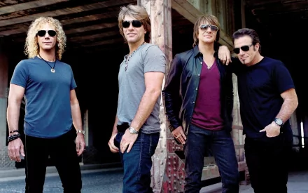 A high-definition wallpaper featuring the iconic rock band Bon Jovi, showcasing the members posed confidently against a rustic backdrop.