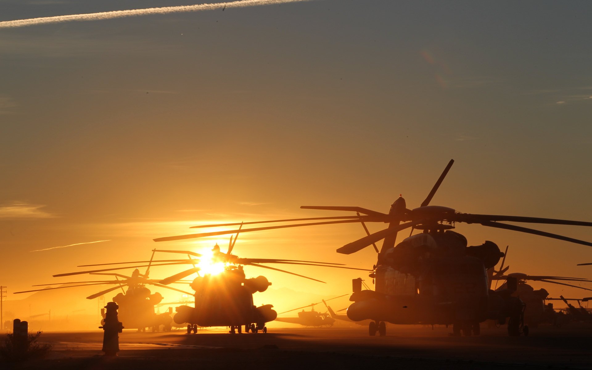 HD desktop wallpaper featuring military Sikorsky CH-53E Super Stallion helicopters silhouetted against a vibrant sunset sky.