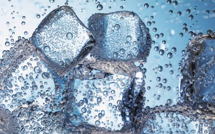 Close-up of ice cubes submerged in clear water, surrounded by bubbles, creating a refreshing and dynamic visual. This striking image serves as an HD desktop wallpaper and background.