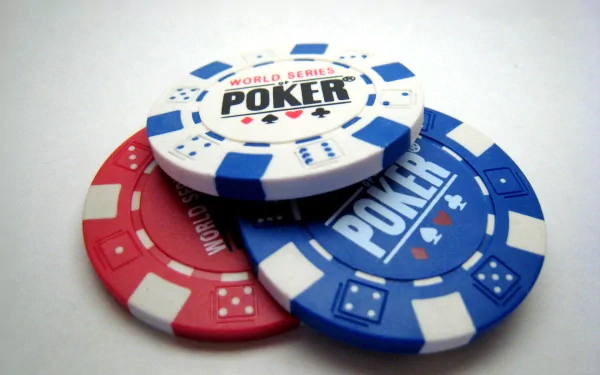HD desktop wallpaper featuring a close-up of three man-made poker chips in red, blue, and white, with World Series Poker text on the white chip.