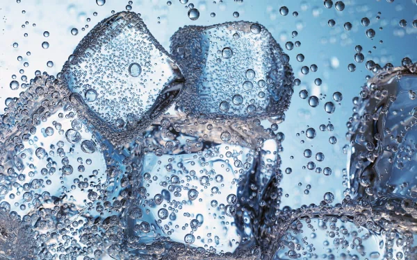 Close-up of ice cubes submerged in clear water, surrounded by bubbles, creating a refreshing and dynamic visual. This striking image serves as an HD desktop wallpaper and background.