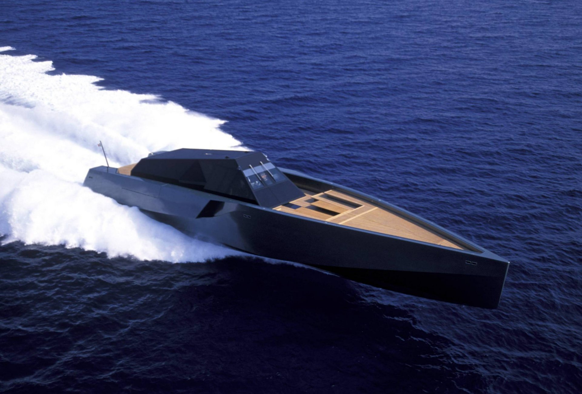 A sleek Strand Craft 122 boat speeding across deep blue water, captured in high definition as a dynamic PC desktop wallpaper and background.