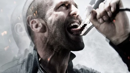 HD desktop wallpaper featuring Jason Statham from the movie Crank: High Voltage, showing him gripping pliers near his mouth with an intense expression.