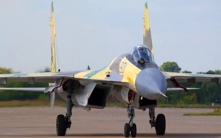 HD desktop wallpaper featuring a military Sukhoi Su-35 jet fighter on the runway, showcasing its sleek design and powerful stance.
