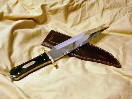 Firefly (TV Show) themed 2K Quad HD PC desktop wallpaper: polished bowie knife with leather sheath resting on wrinkled tan fabric.