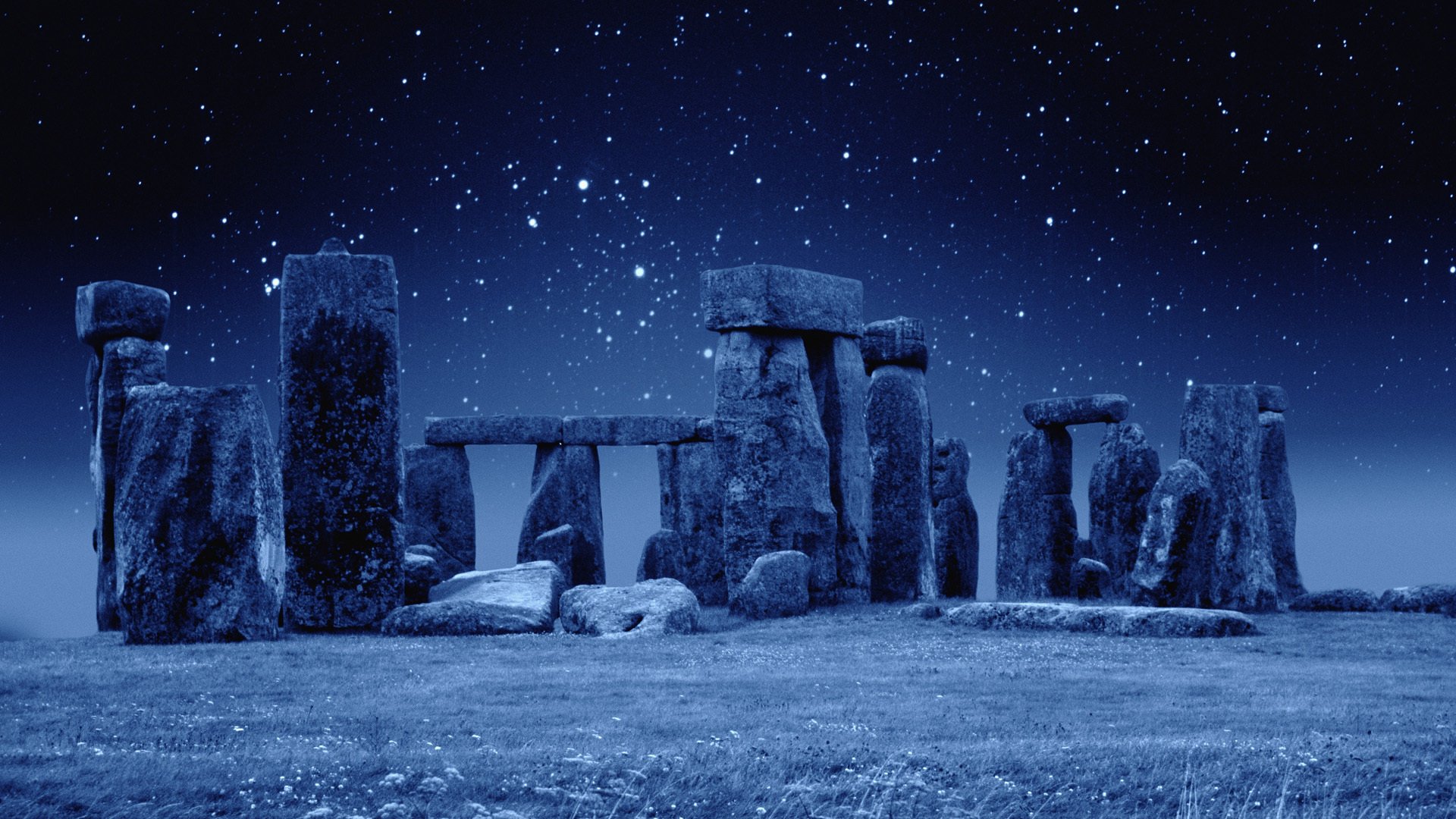 HD desktop wallpaper featuring Stonehenge at night under a starry sky, highlighting this iconic man-made prehistoric monument.