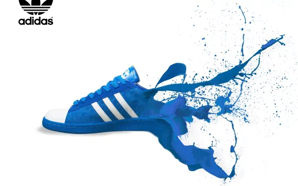 A vibrant HD desktop wallpaper featuring a blue Adidas sneaker with a splash of paint, showcasing a dynamic and creative design. The Adidas logo is prominently displayed at the top.