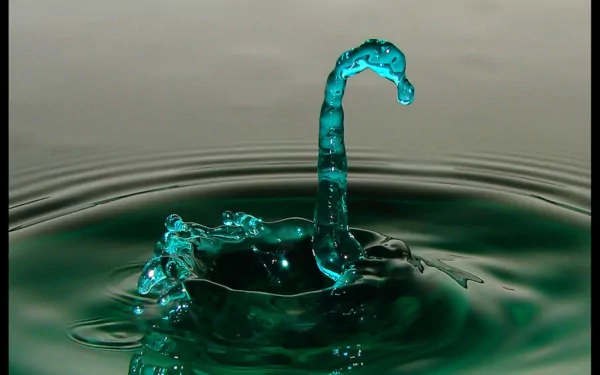 An artistic HD wallpaper featuring a striking water splash with a fluid, turquoise shape emerging from the surface, creating a captivating visual effect.