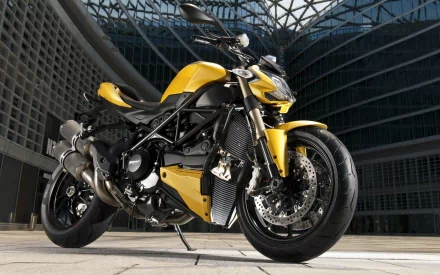 HD PC desktop wallpaper featuring a yellow Ducati Streetfighter motorcycle parked in a modern architectural setting.