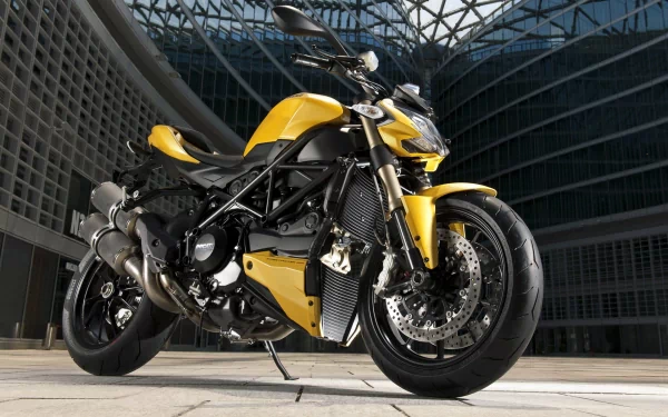 HD PC desktop wallpaper featuring a yellow Ducati Streetfighter motorcycle parked in a modern architectural setting.