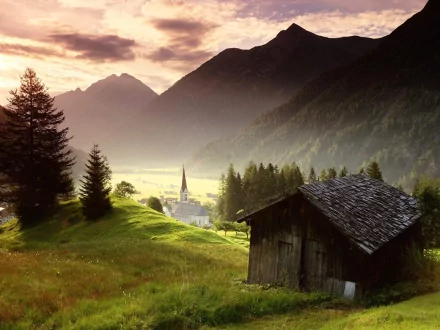 A serene desktop wallpaper featuring a lonely cabin nestled in the hills, surrounded by lush greenery and distant mountains under a soft, golden sunset sky.
