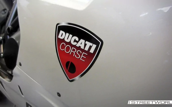 Close-up of a white Ducati motorcycle fairing featuring a red Ducati Corse badge — HD PC desktop wallpaper and background.