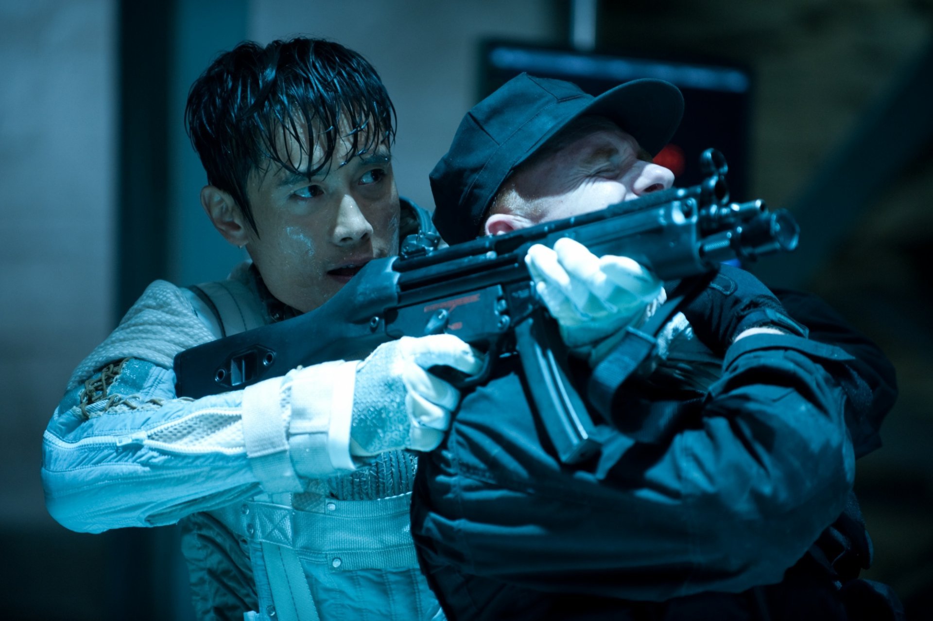 HD PC desktop wallpaper: tense scene from G.I. Joe: Retaliation — drenched operative wrestles a rifle from a uniformed assailant in a dim, blue-lit corridor.