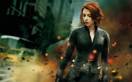 Natasha Romanoff, known as Black Widow, portrayed by Scarlett Johansson, stands amid an explosive scene from the Avengers movie, showcasing her strength and determination.