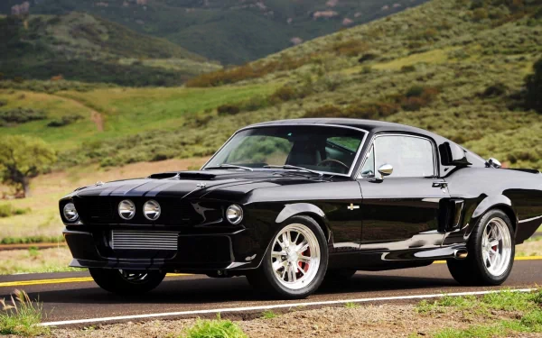 A sleek black Ford vehicle parked on a winding road, surrounded by lush green hills, showcasing its classic design and striking features. HD desktop wallpaper and background image.