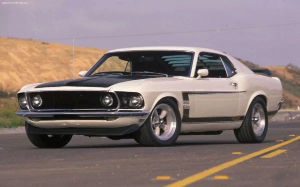 A classic Ford muscle car, featuring a sleek white and black design, showcases its powerful stance on a scenic road, embodying the spirit of hot rod culture in stunning HD detail.