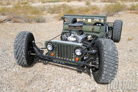 HD desktop wallpaper featuring a rugged Jeep vehicle with oversized wheels, captured in a desert landscape. The Jeep's front grill and engine are prominently visible.