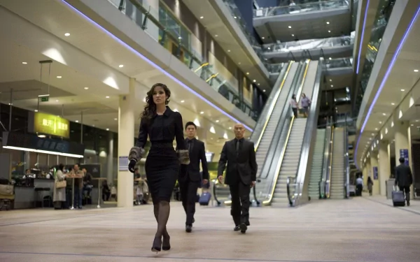 Sévérine, played by Bérénice Marlohe in the James Bond movie Skyfall, walks confidently through a modern building interior in this HD PC desktop wallpaper.