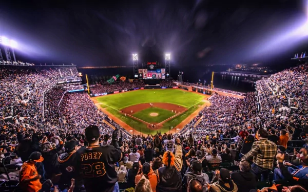 HD PC desktop wallpaper showing a packed San Francisco Giants baseball stadium at night, filled with fans under bright stadium lights.