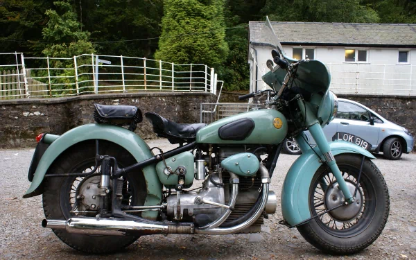 A vintage motorcycle parked beside a building, captured in high detail for a 4K Ultra HD PC desktop wallpaper and background.
