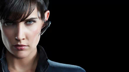 A striking HD wallpaper featuring Cobie Smulders as Maria Hill, showcasing her intense expression and tactical gear against a simple black background from the Avengers movie series.