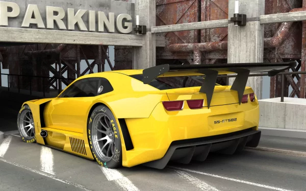 Yellow Chevrolet Camaro vehicle parked in an industrial lot, rear three-quarter view with large spoiler and wide wheels — HD PC desktop wallpaper/background.