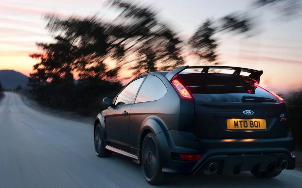 HD PC desktop wallpaper featuring a dynamic rear view of a Ford Focus RS500 in motion during sunset, highlighting the sporty design of the Ford Focus RS vehicle.