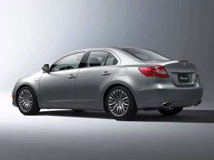Silver Suzuki sedan shown from rear three-quarter view on a neutral gray backdrop — HD PC desktop wallpaper and background.