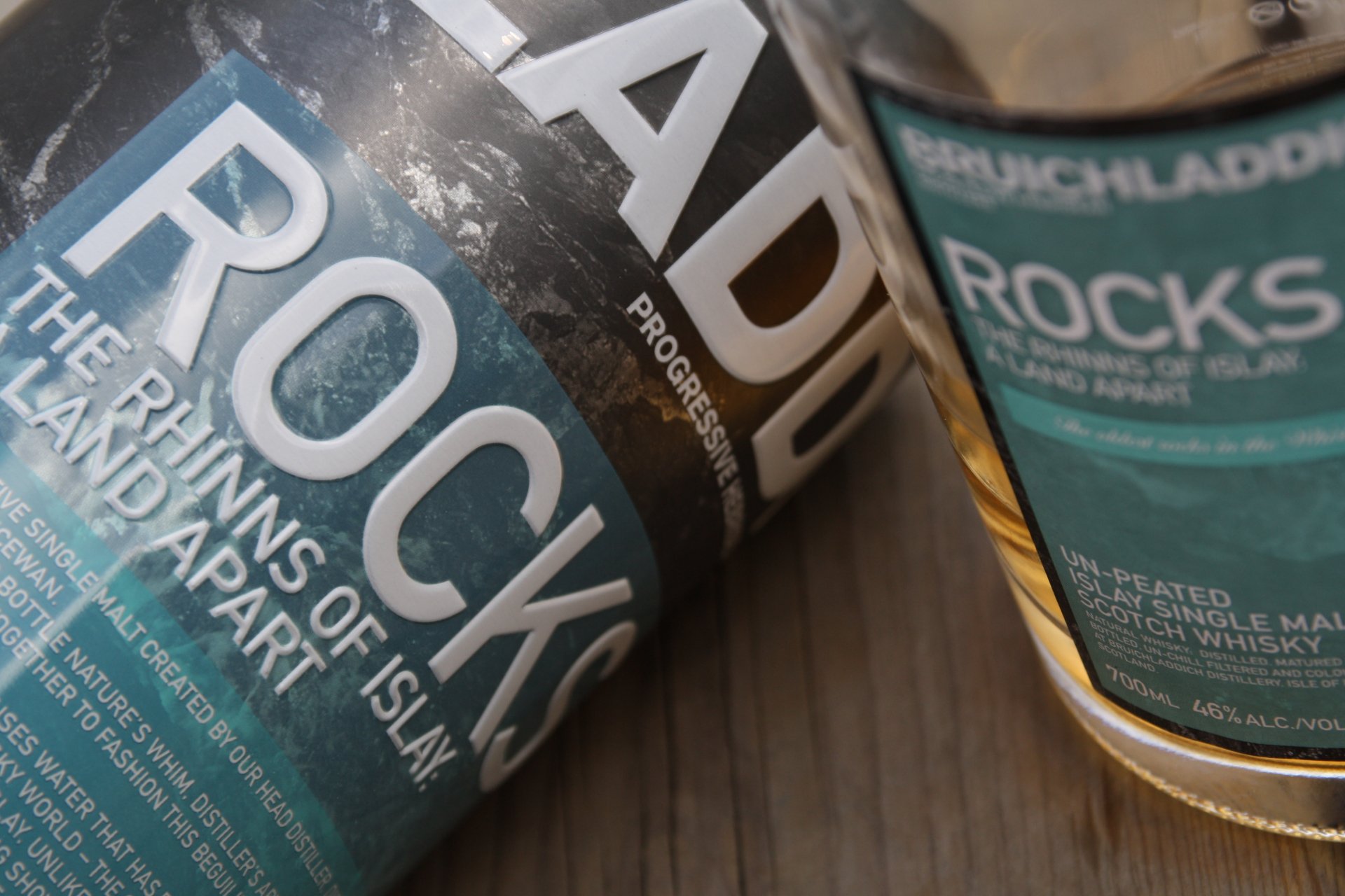 A close-up of Bruichladdich Rocks Scotch whisky bottles displays elegant labeling against a textured surface, showcasing the essence of Islay malt and fine spirits.