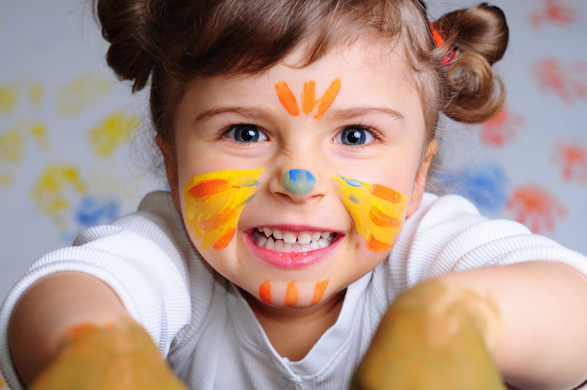 A smiling child with face paint and playful handprints, captured in vibrant photography, rendered as a 4K Ultra HD PC desktop wallpaper and background.