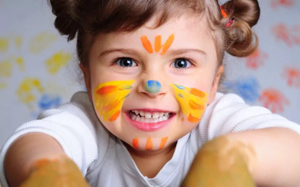 A smiling child with face paint and playful handprints, captured in vibrant photography, rendered as a 4K Ultra HD PC desktop wallpaper and background.
