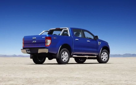 A vibrant blue Ford Ranger parked on a vast, open landscape under a clear blue sky, showcased as a high-definition desktop wallpaper and background.
