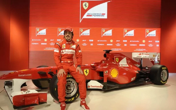 HD PC wallpaper: Spanish F1 driver in red Ferrari racing suit posing beside a red Ferrari F1 car against a racing-themed sports backdrop.