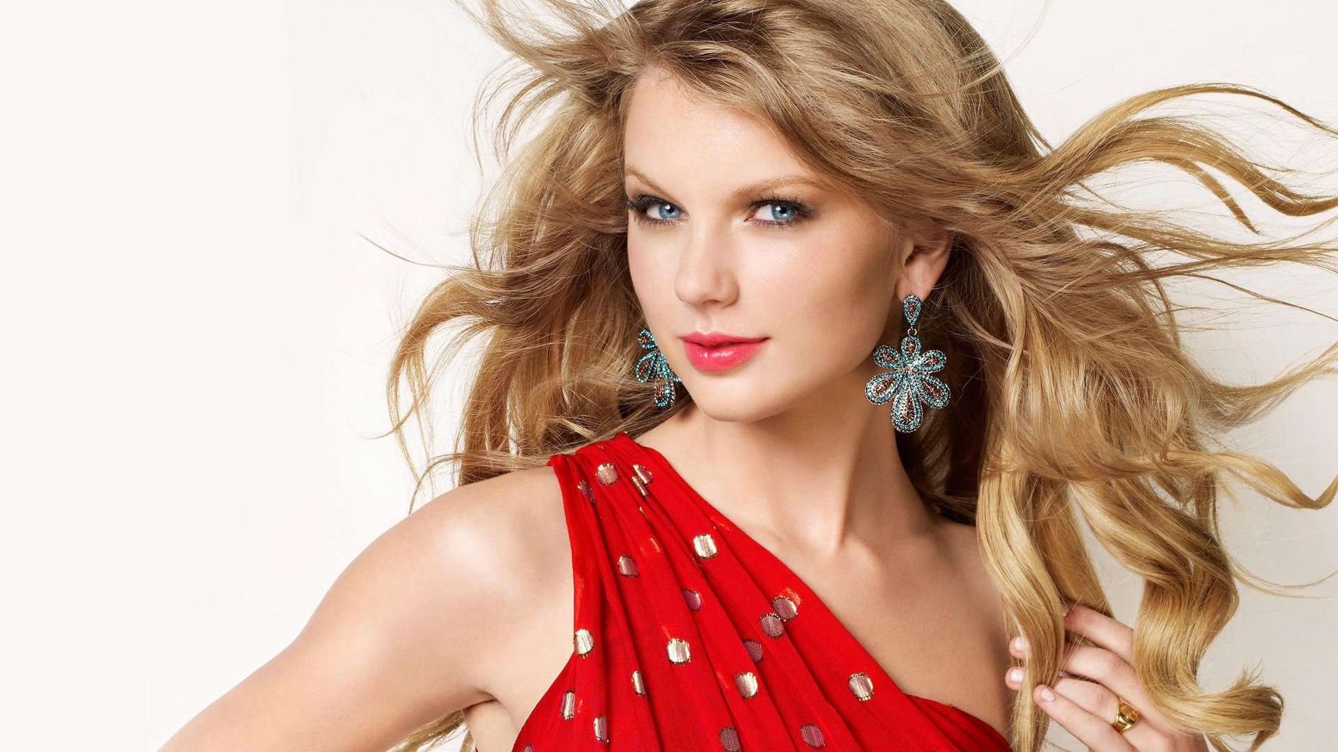 A vibrant HD desktop wallpaper featuring a glamorous Taylor Swift in a striking red dress, showcasing her signature style and charisma.