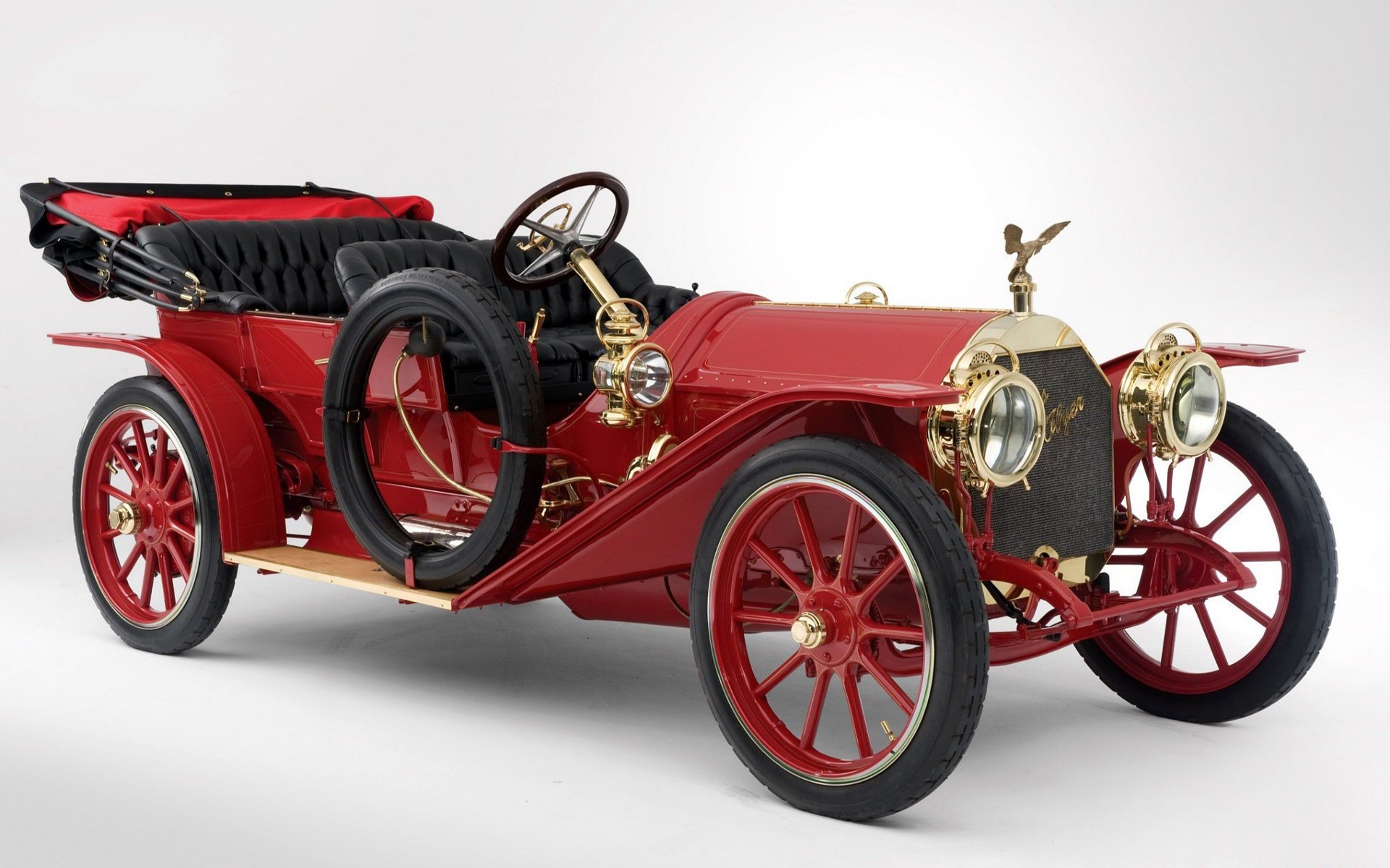 HD desktop wallpaper featuring a classic vintage car, showcasing an old, red vehicle with detailed brass accents and a black leather interior.