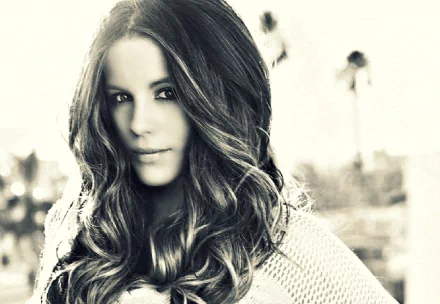A striking black-and-white portrait of actress Kate Beckinsale, featuring her with flowing hair and an elegant expression, serving as a HD desktop wallpaper.