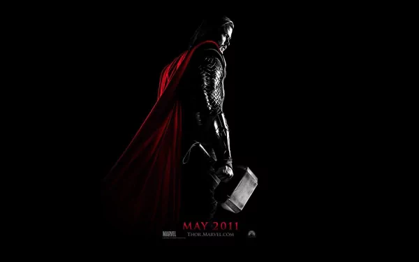 A striking HD wallpaper featuring Chris Hemsworth as Thor, showcasing the character's iconic look with his hammer and red cape against a dark background. May 2011 release.