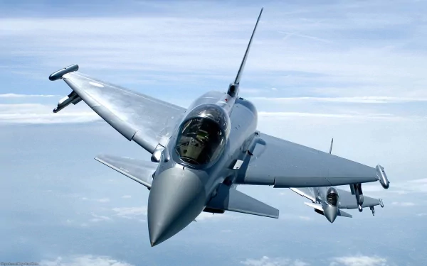 HD desktop wallpaper showing a Eurofighter Typhoon military jet flying above the clouds with a clear sky background.