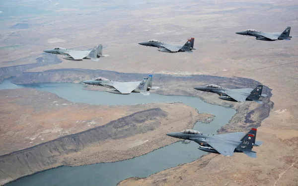 HD desktop wallpaper featuring a formation of McDonnell Douglas F-15 Eagle military jets flying over a river landscape.
