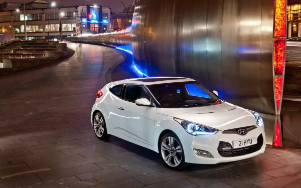 White Hyundai Veloster car parked on a city street at night, showcased as an HD PC desktop wallpaper and background.
