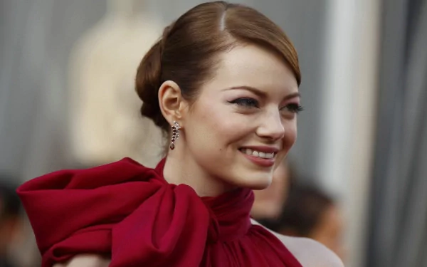 HD PC desktop wallpaper of celebrity Emma Stone smiling, wearing a stylish red outfit with an elegant updo hairstyle.