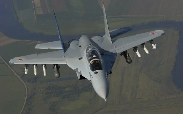HD desktop wallpaper featuring a Mikoyan MiG-35 military fighter jet in flight over a blurred landscape background.