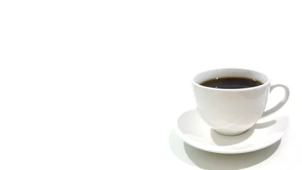 HD desktop wallpaper of a white cup filled with black coffee, placed on a matching white saucer, against a minimalist white background.
