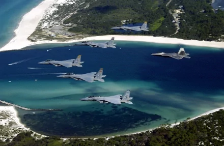 Aerial view of McDonnell Douglas F-15 Eagles flying over Panama City, Florida, showcasing military might against a stunning coastal landscape. HD desktop wallpaper.